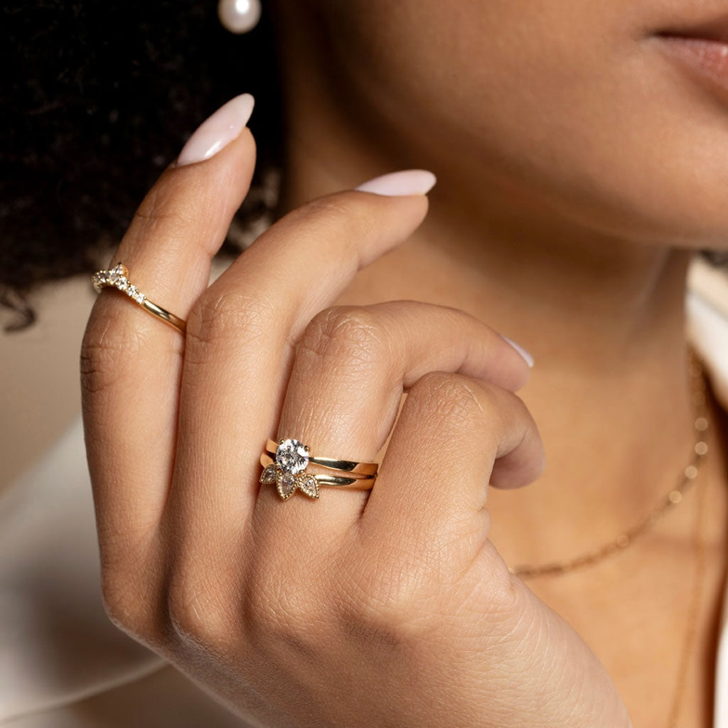 Lady wearing set of gold engagement ring and shaped wedding band