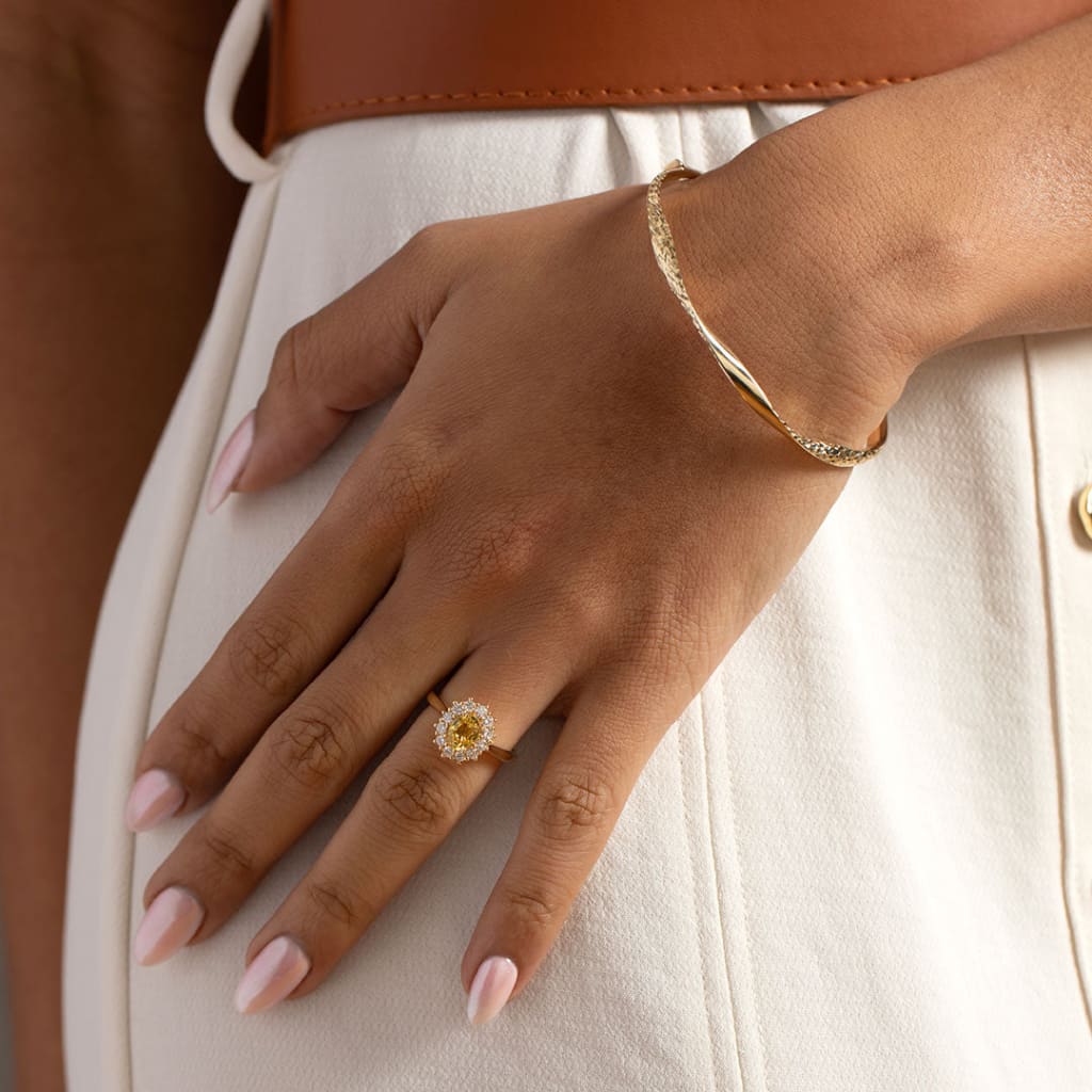 model wearing engagement ring and gold bangle