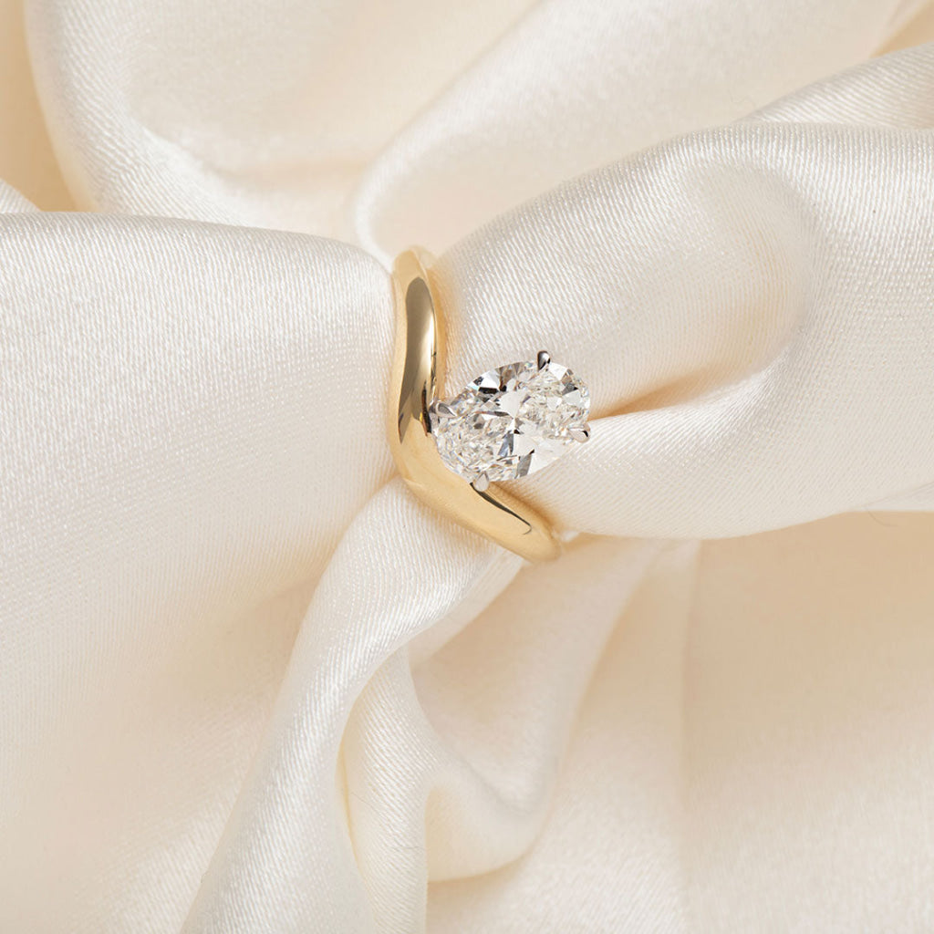 oval cut engagement ring on silk fabric