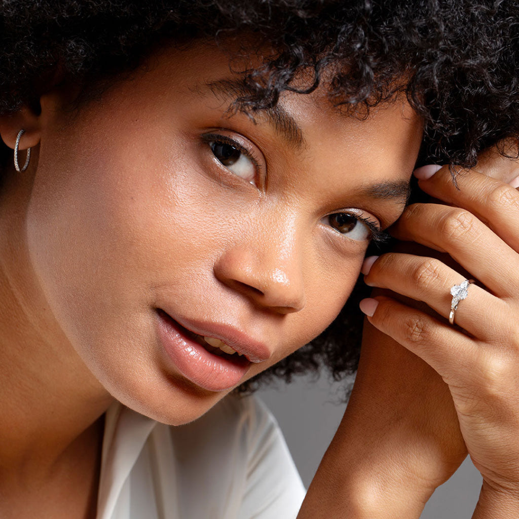 Close up of model wearing Oval three stone engagement ring