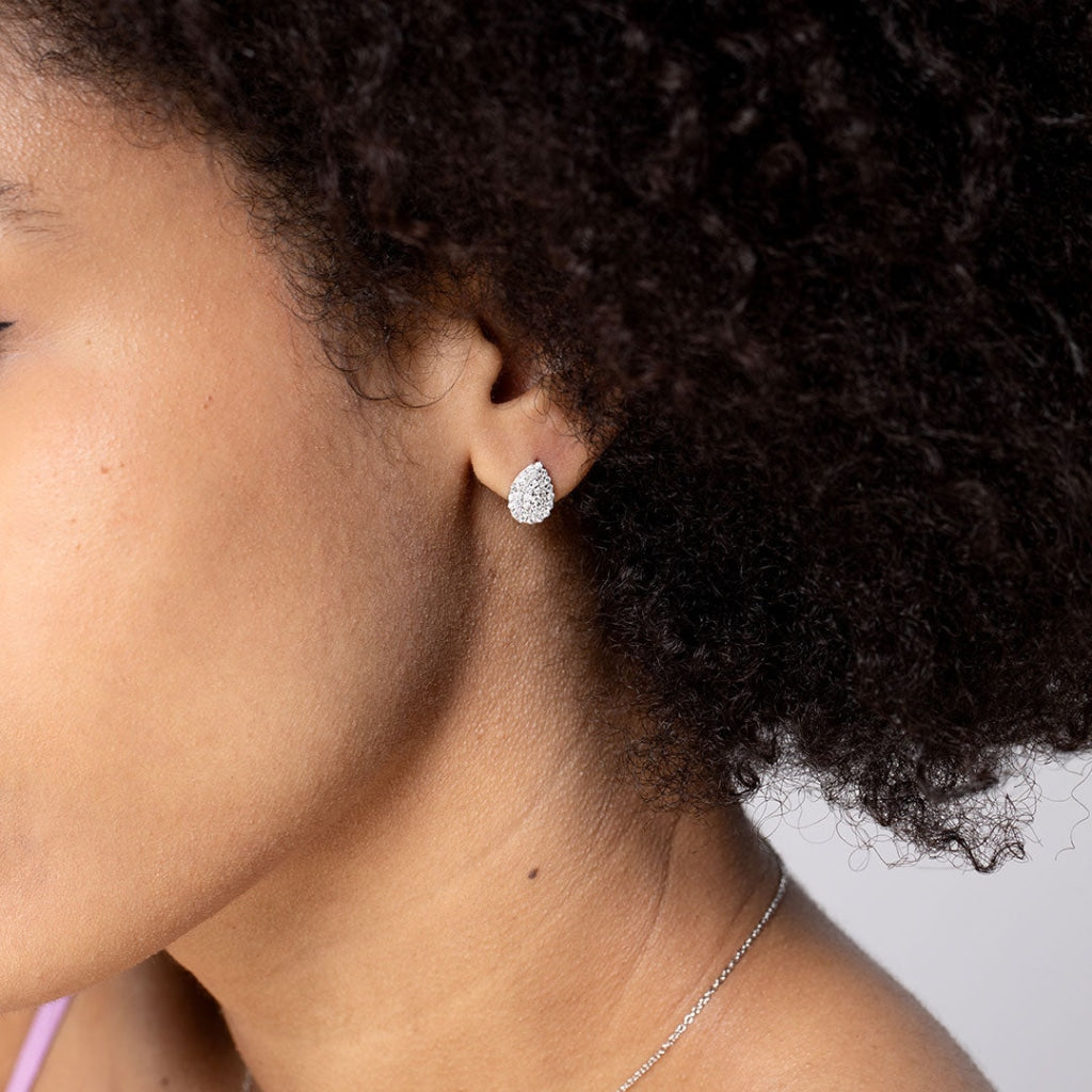 Model wearing pear shape diamond earrings