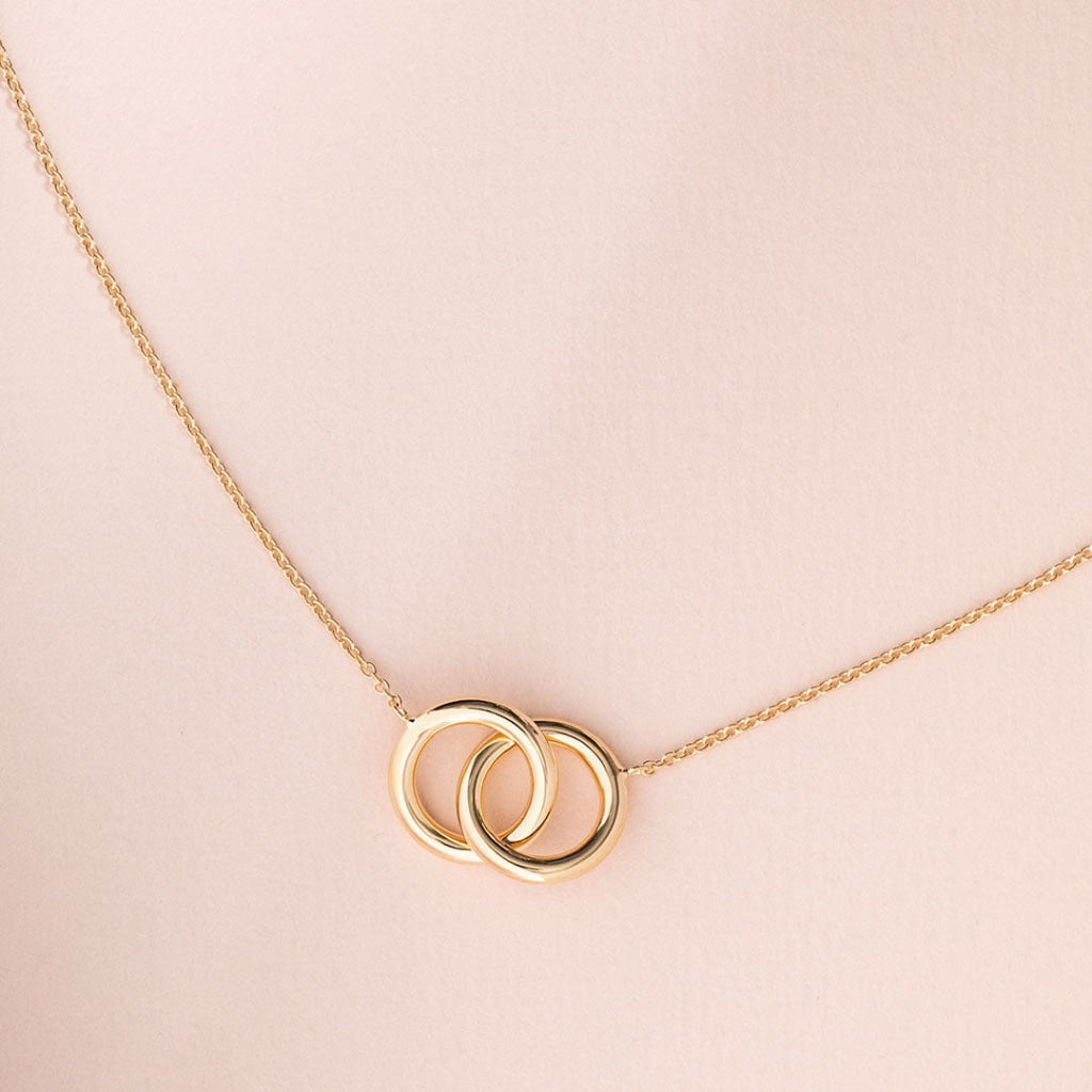 Together Forever 9ct gold circle necklace on pink background