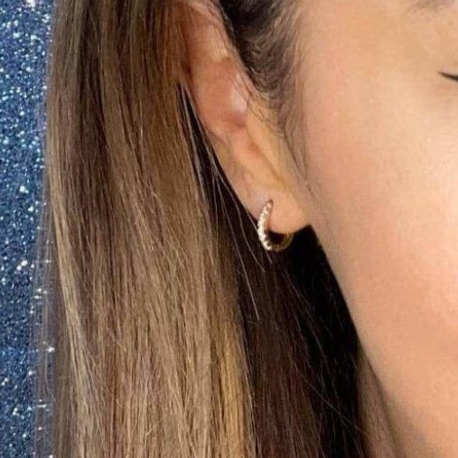 Woman wearing 9ct gold Petite CZ Huggie Earrings | Gear Jewellers Dublin