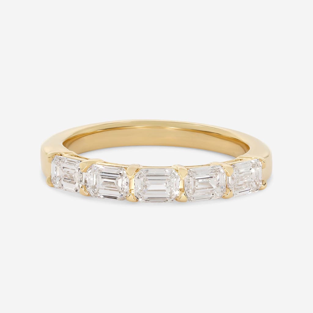 yellow gold emerald cut band on white background