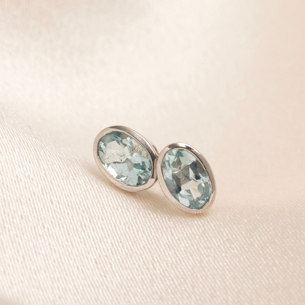 aquamarine oval cut bezel set earrings in white gold
