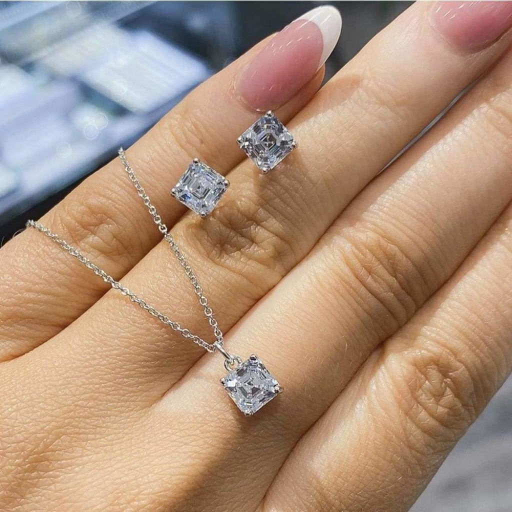 Asscher Cut Cubic Zirconia Earrings and matching necklace in womans hand.