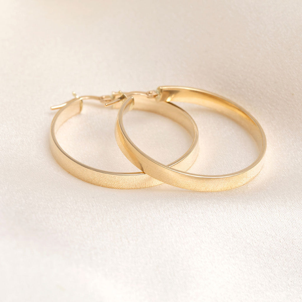 30mm 14ct gold hoops on a cream fabric background