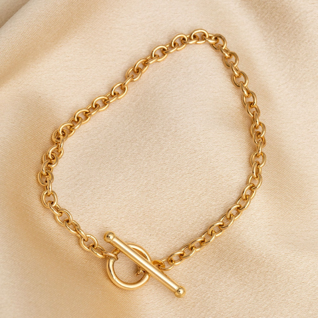 9ct gold T bar bracelet on cloth background