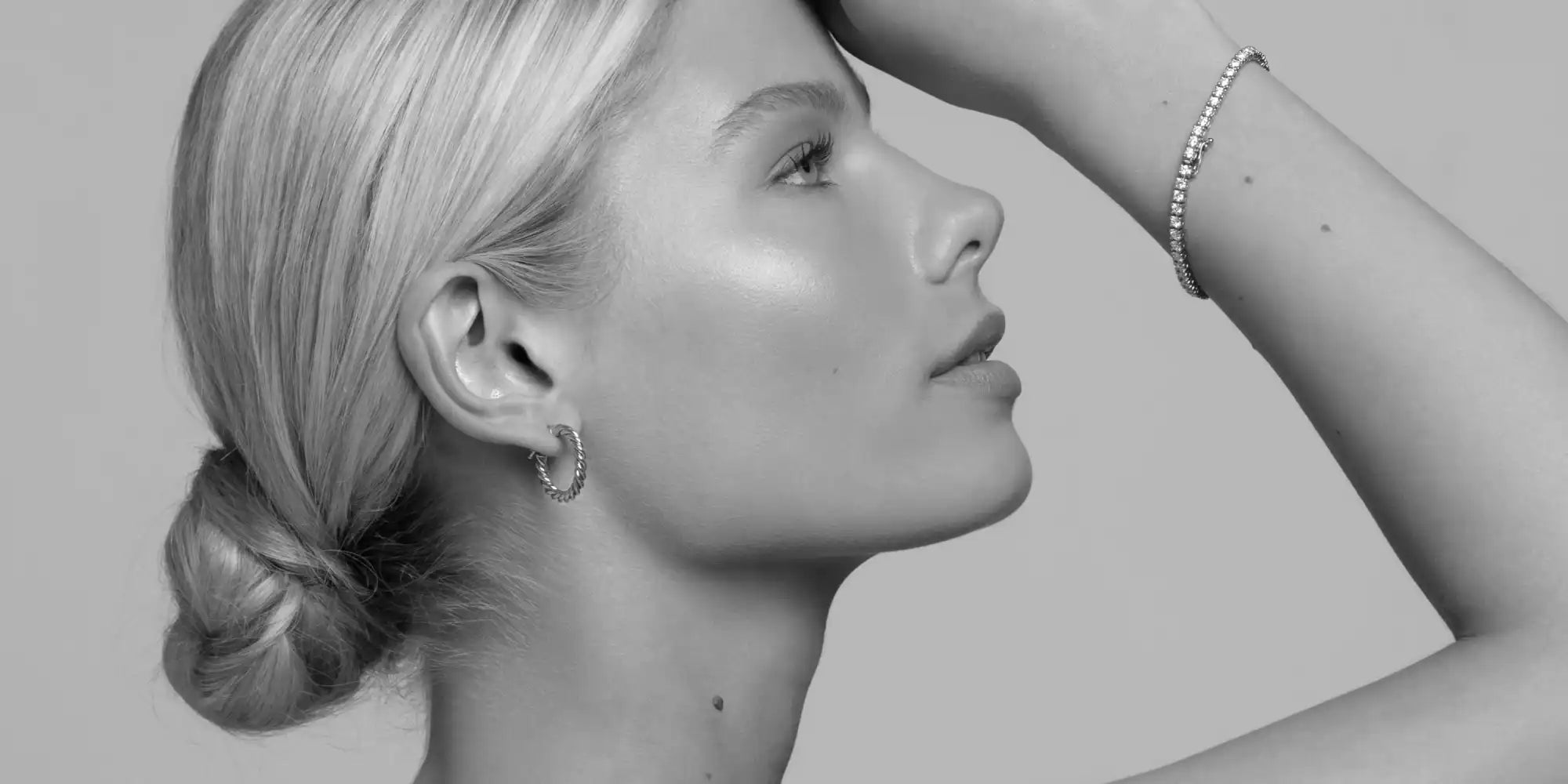 Black and white profile portrait showing an elegant upward gaze and sleek low bun hairstyle.