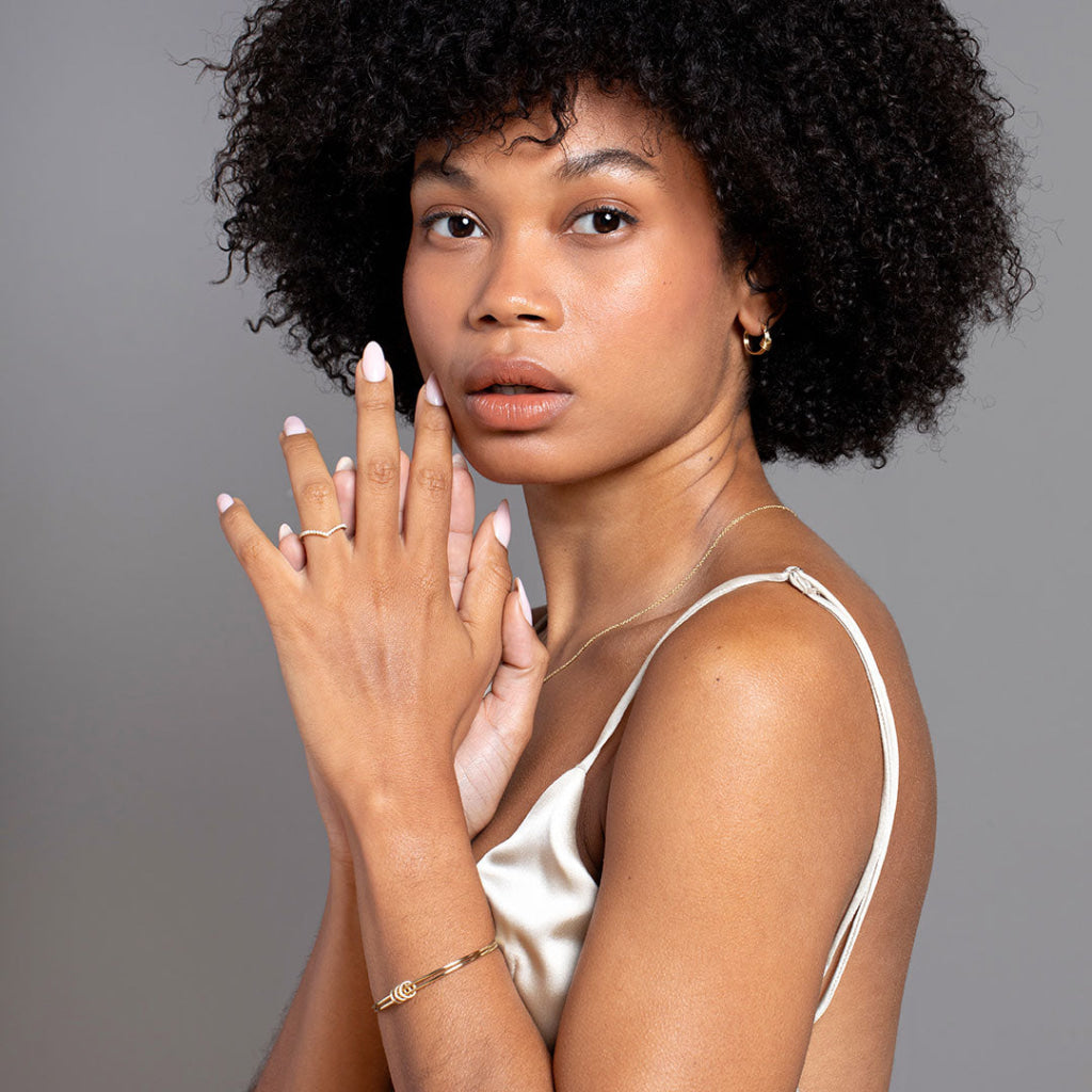 Model showcasing gold diamond curved wedding band