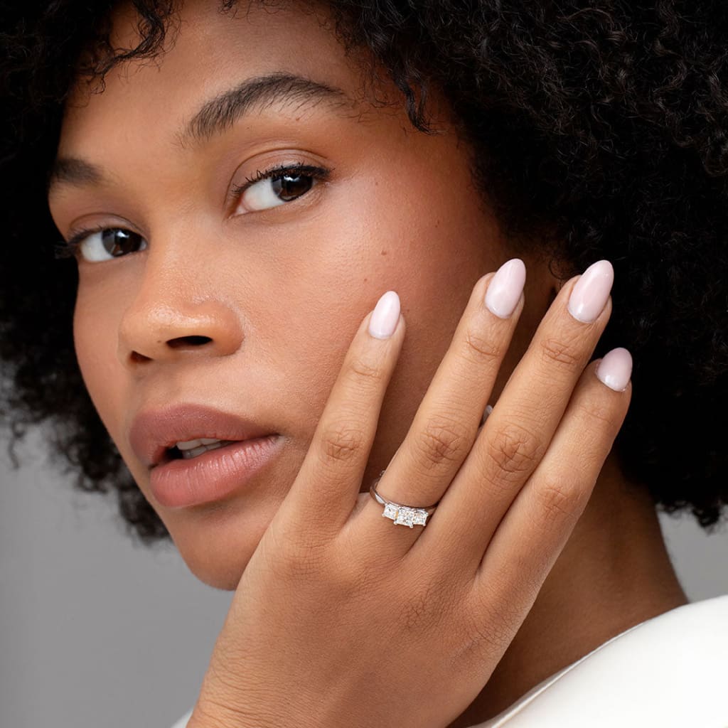 Model wearing three stone diamond engagement ring