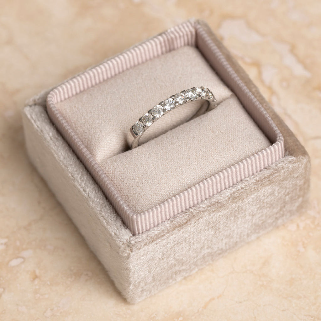 Diamond ring in a jewelry box on a beige surface