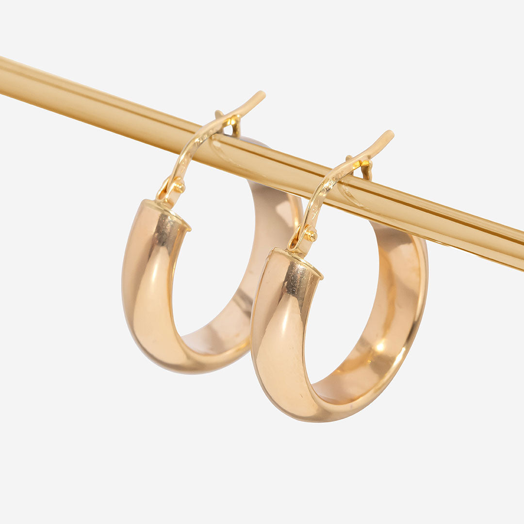 Gold chunky hoops hanging on bar
