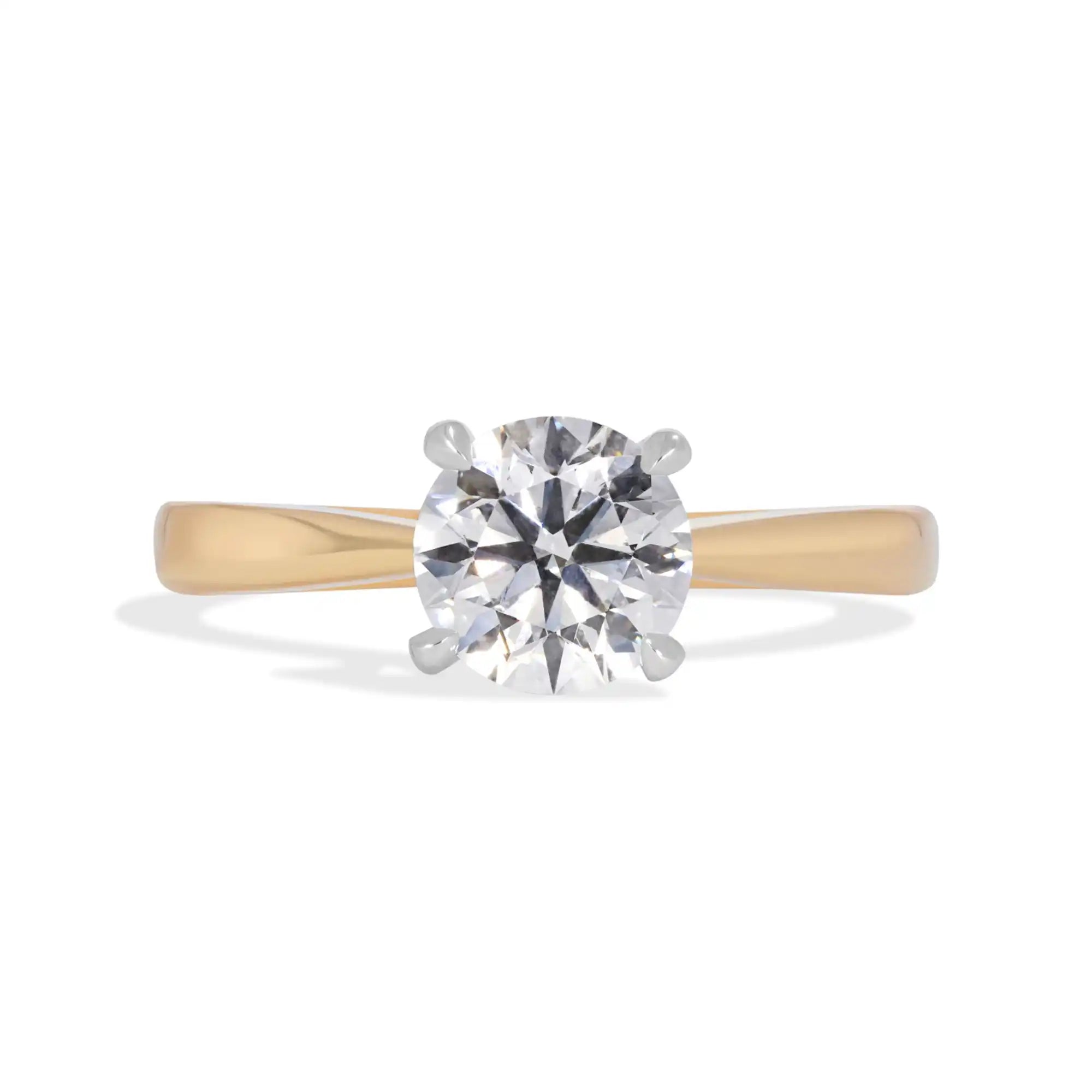 Classic solitaire diamond engagement ring with yellow gold band and white gold prongs.