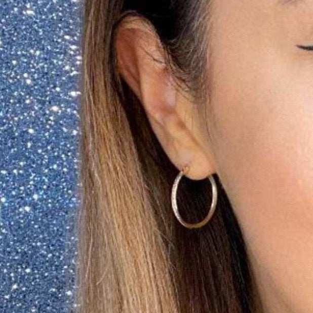 Woman wearing 9ct gold Thin Plain Hoop Earrings 25mm | Gear Jewellers Dublin