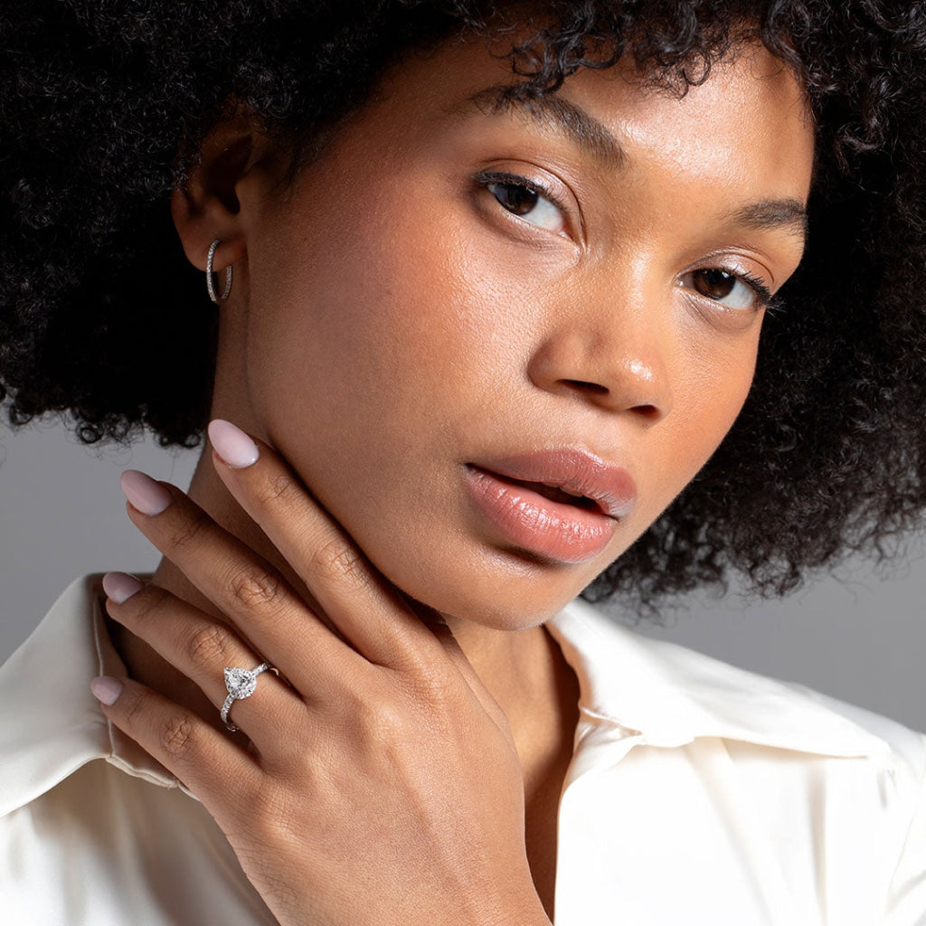 Model with hand on neck wearing pear diamond engagement ring