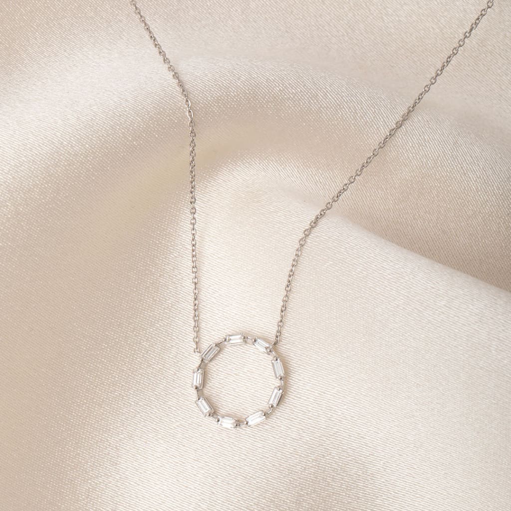 white gold diamond circle necklace on satin background