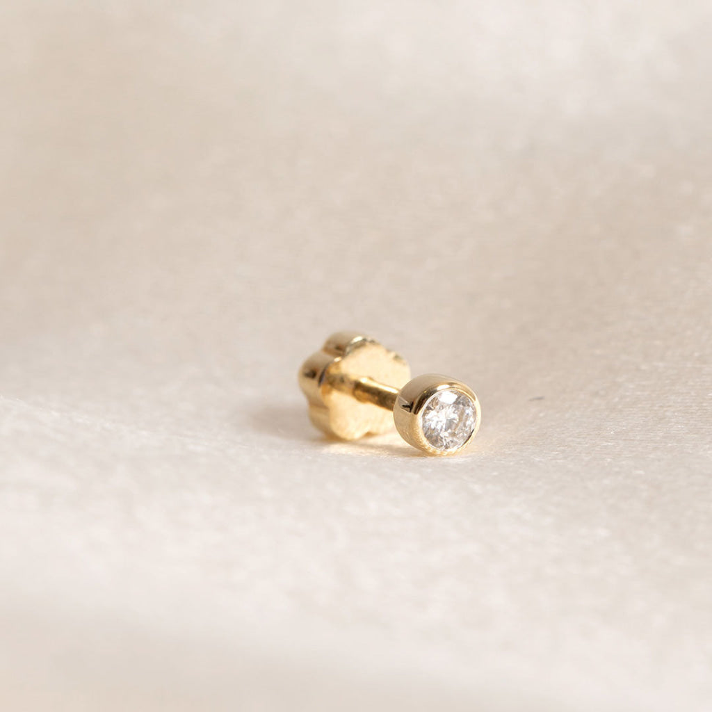 yellow gold diamond bezel set piercing