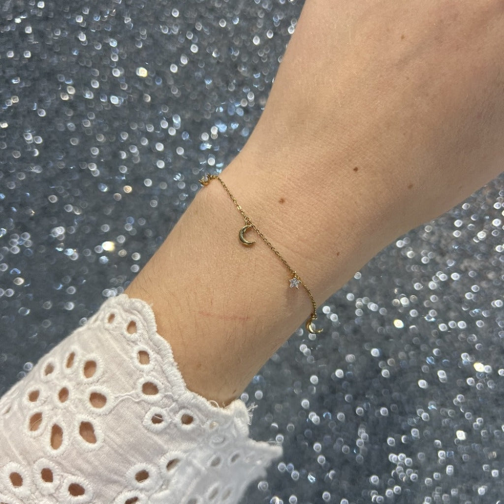 Woman's wrist wearing diamond charm bracelet in 9ct gold