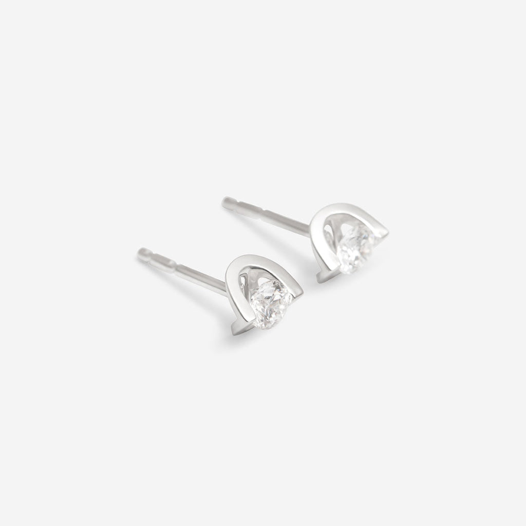 side view of white gold diamond stud earrings on white background