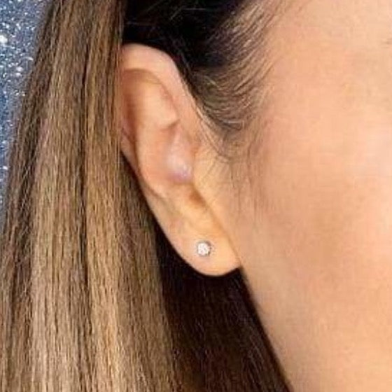 Woman wearing diamond earring.