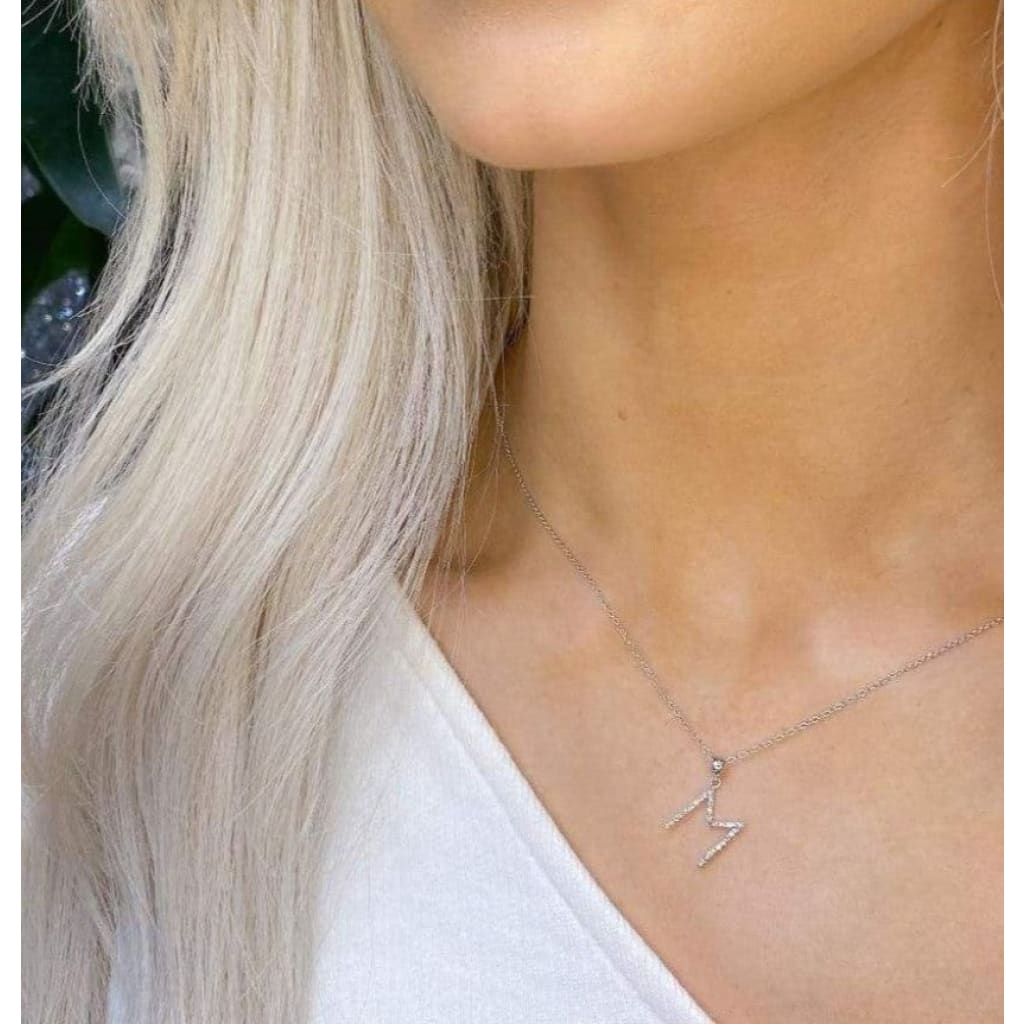 Woman wearing white gold initial necklace