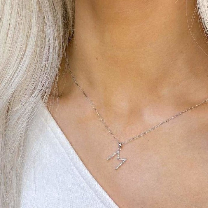 Woman wearing diamond M initial necklace