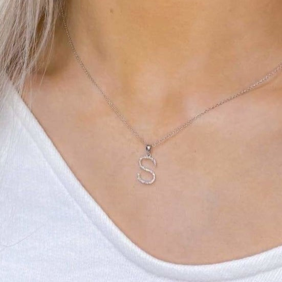 Woman wearing diamond S initial necklace