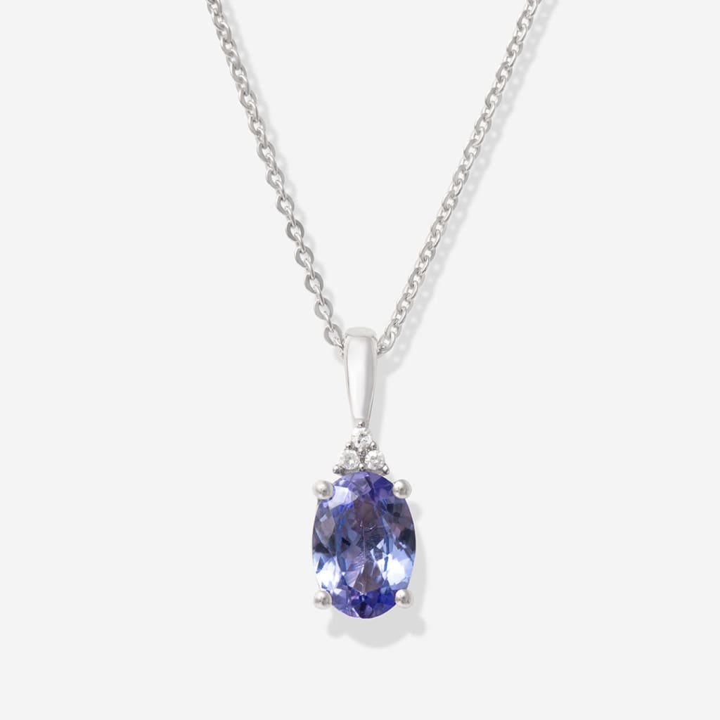 close up of oval cut tanzanite on white background