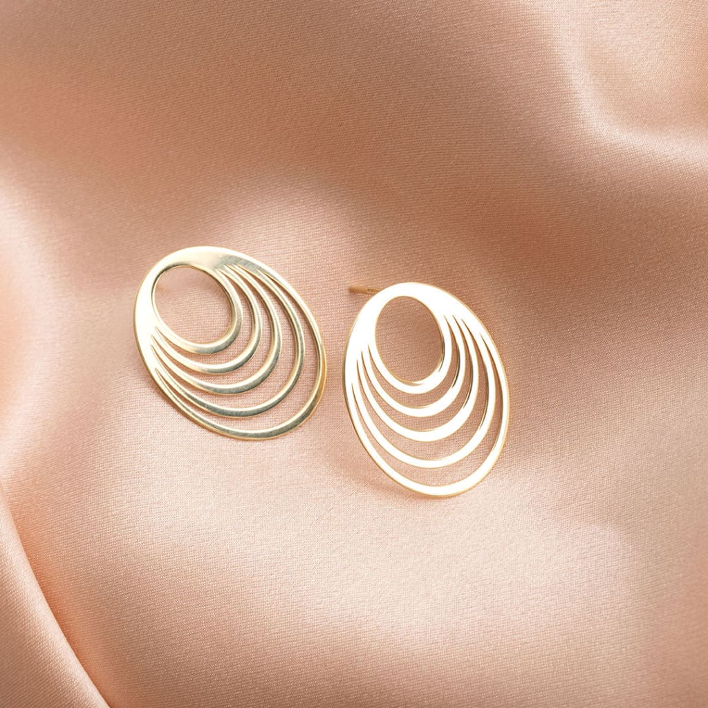 Eclipse gold earrings on fabric