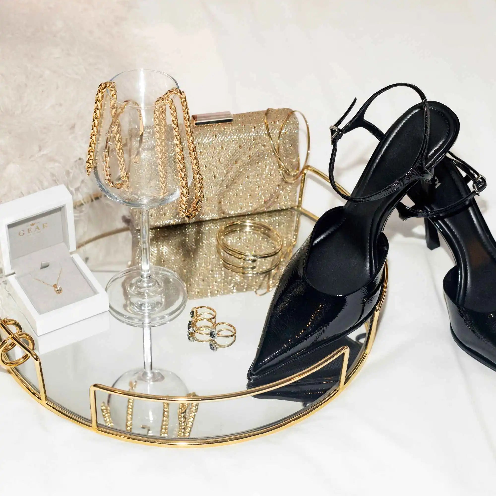 Elegant black high-heeled sandals with gold metallic accents.