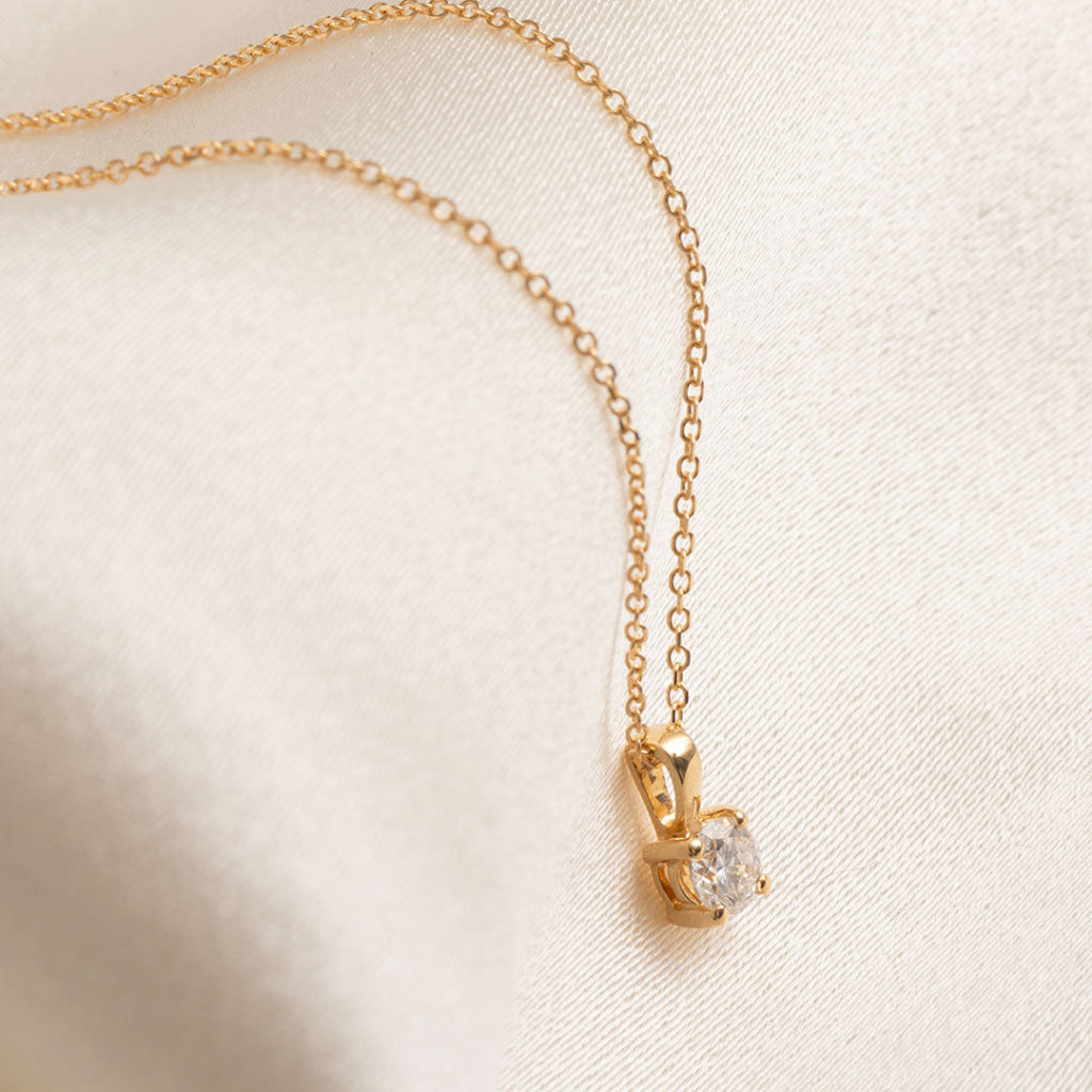 side view of yellow gold diamond pendant on fine chain