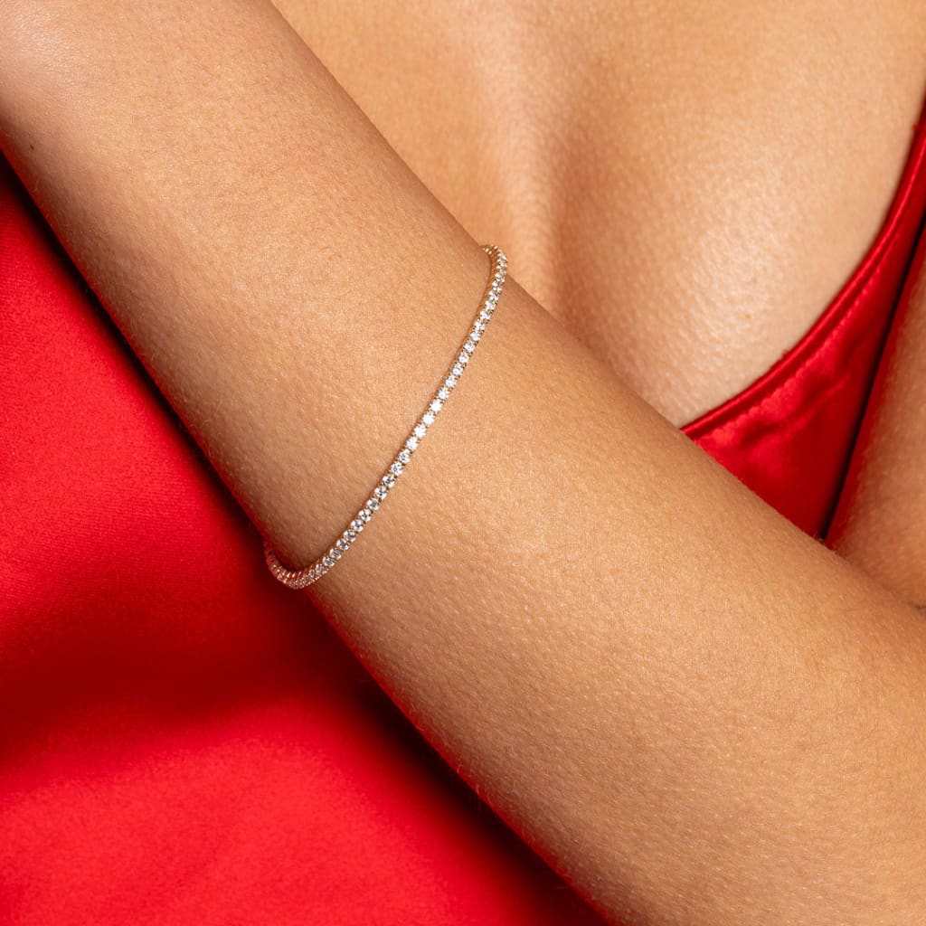 Model in red dress wearing Classic Tennis Bracelet - 2mm 9ct gold Photo 2