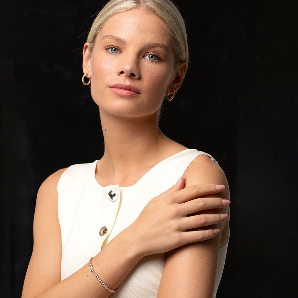 model wearing selection of gold jewellery