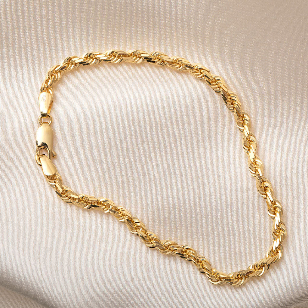 yellow gold rope design bracelet on fabric