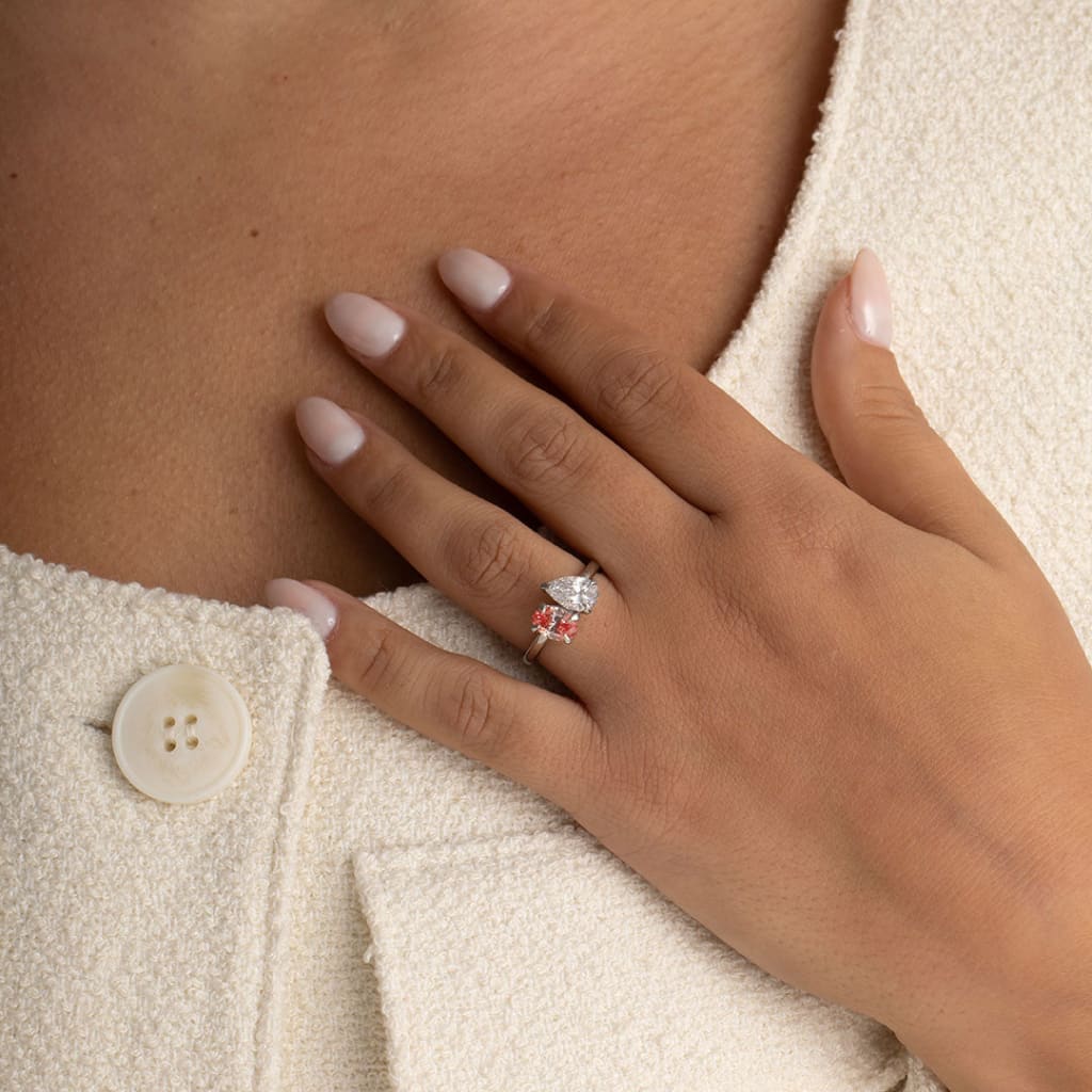 hand shot of model wearing oval and pear shaped lab grown engagement ring