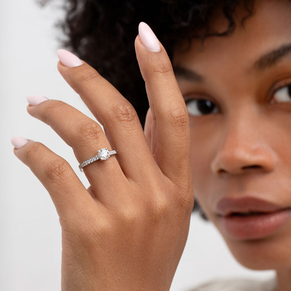 Hand model wearing round engagement ring