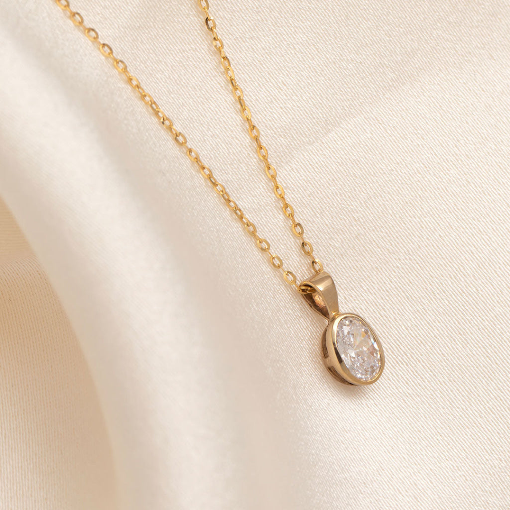 side view of yellow gold oval pendant on chain