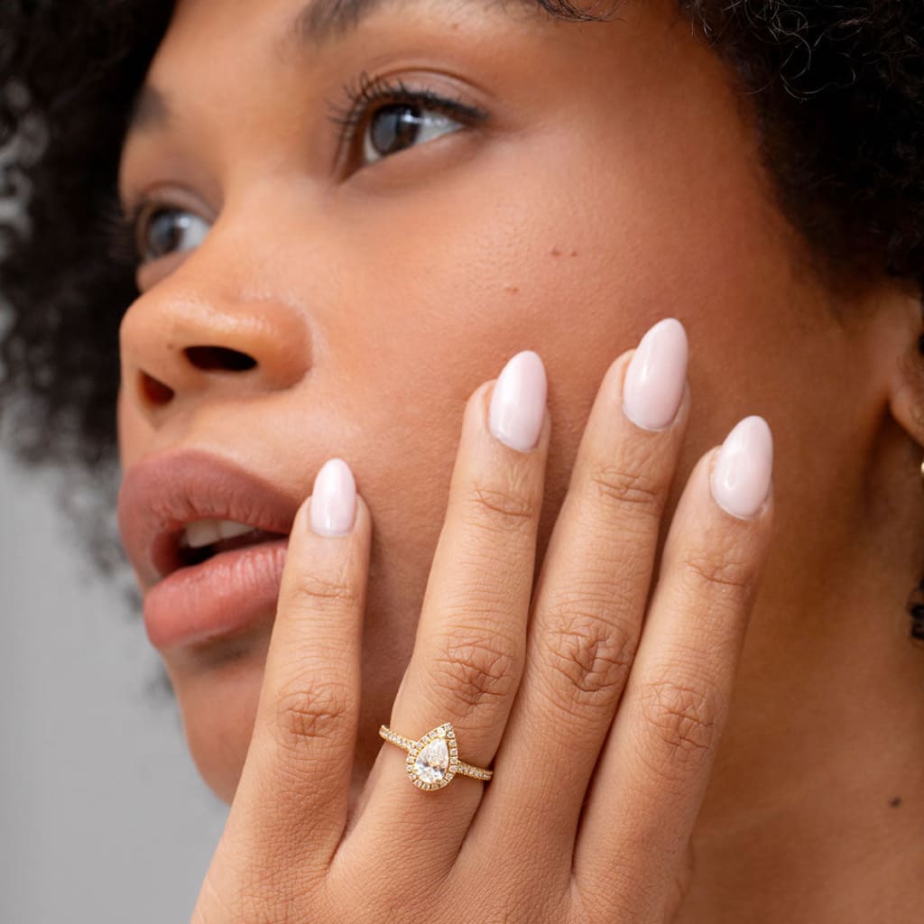 Close up of lady wearing Geneva pear engagement ring