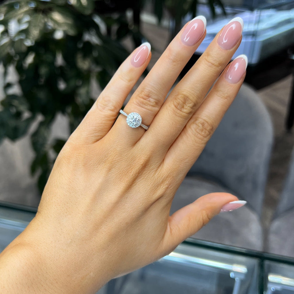 round halo diamond engagement ring on hand
