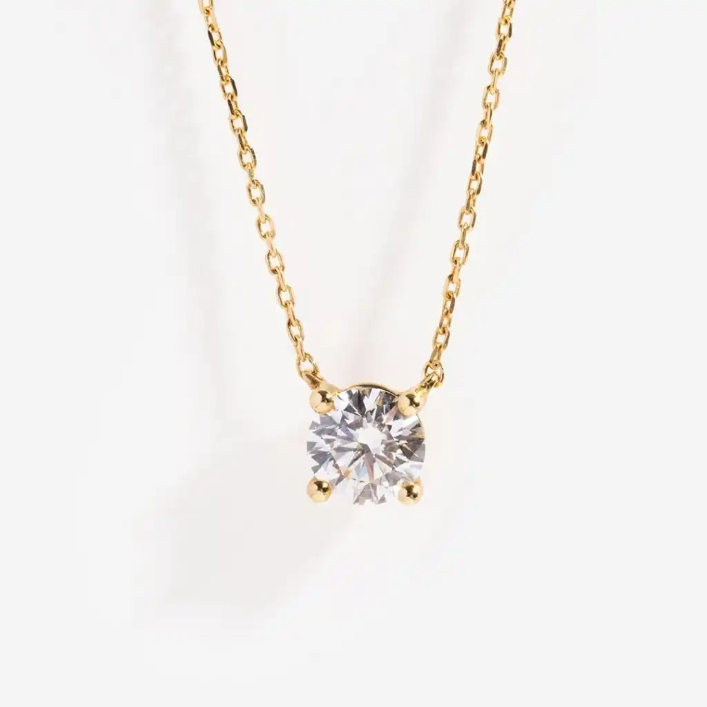 Gold chain necklace featuring a single round diamond solitaire pendant.