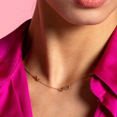 graduated infinity necklace on model wearing pink shirt