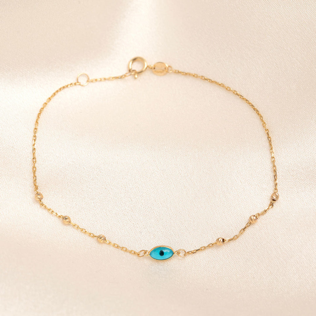 yellow gold beaded chain bracelet with blue eye charm