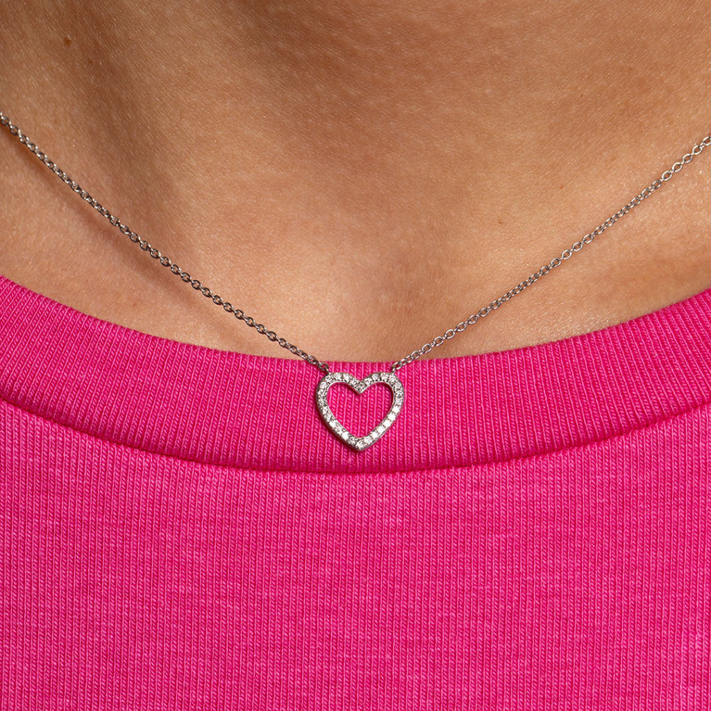 Diamond heart necklace on model wearing pink top