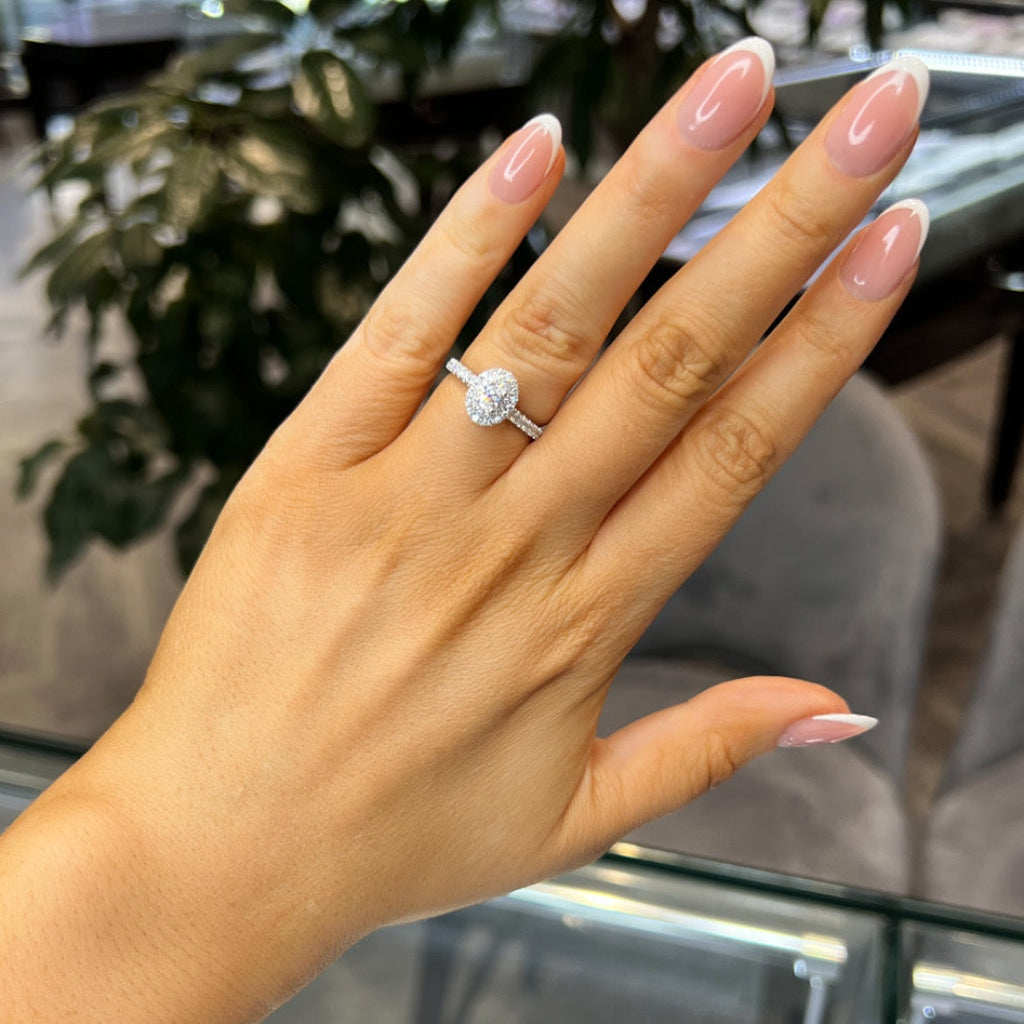 oval halo diamond engagement ring on hand