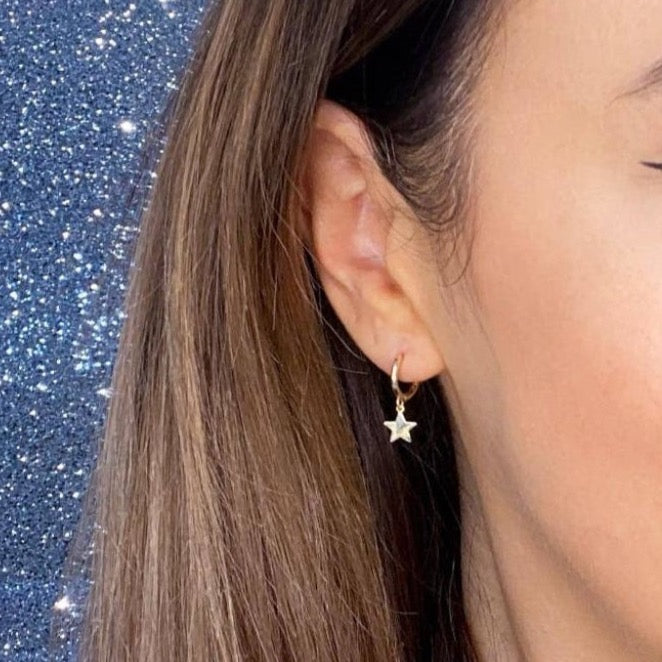 Woman wearing 9ct gold Huggies with Star Charm | Gear Jewellers Dublin