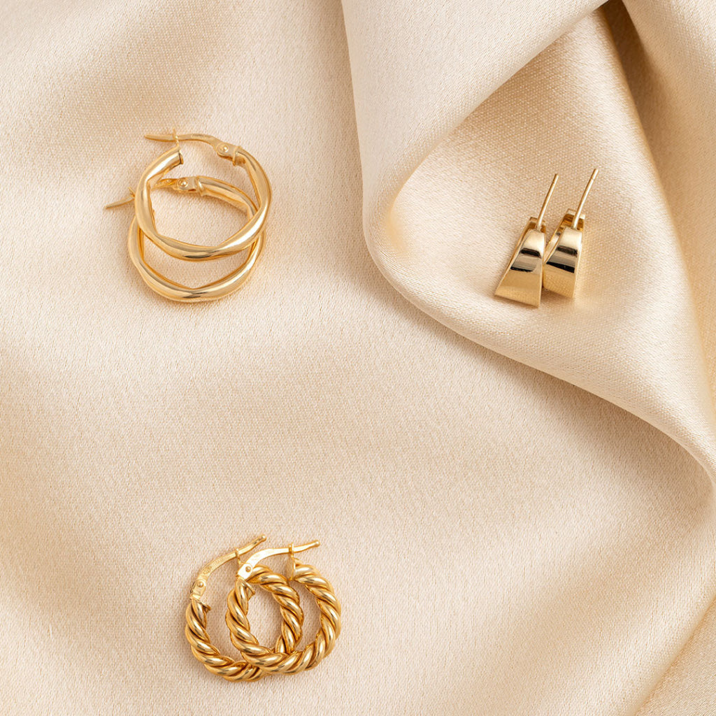 three pairs of gold hoops on fabric