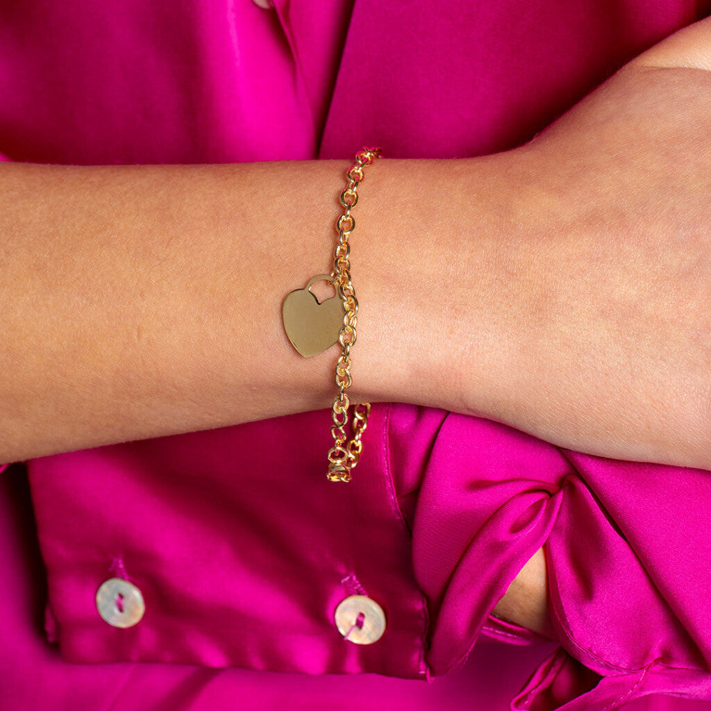 gold heart bracelet on model with pink blouse