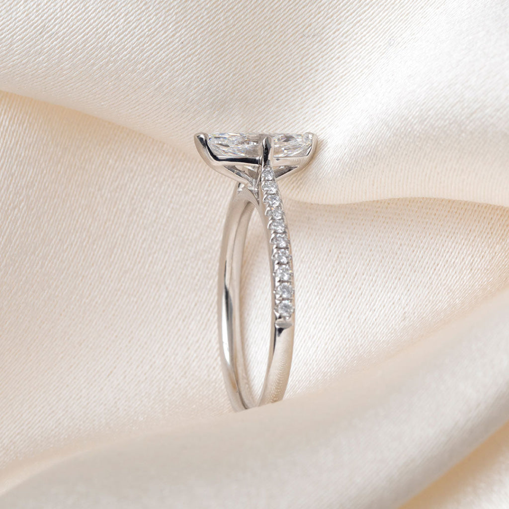 A platinum diamond ring featuring a marquise-cut center stone and pavé-set diamonds along the band.