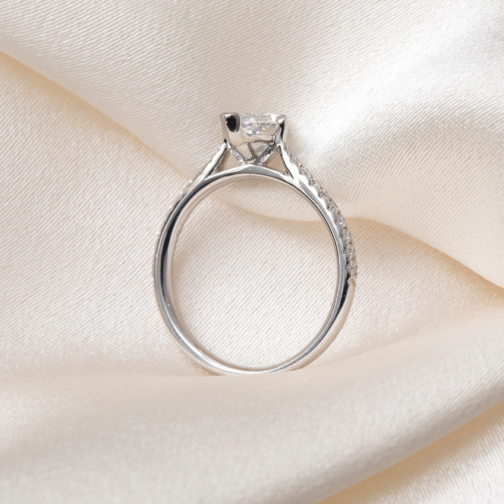 A platinum diamond ring featuring a marquise-cut center stone and pavé-set diamonds along the band.